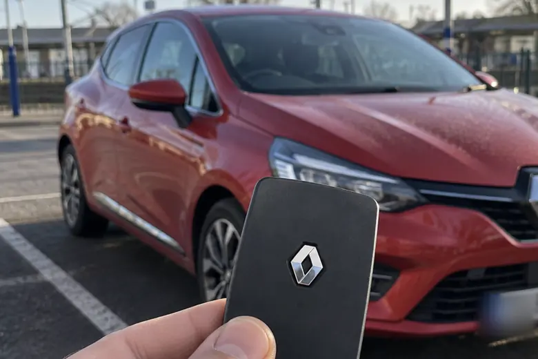 A car key held in front of a Renault Clio