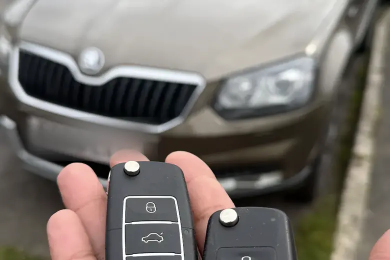 A car key held in front of a Skoda